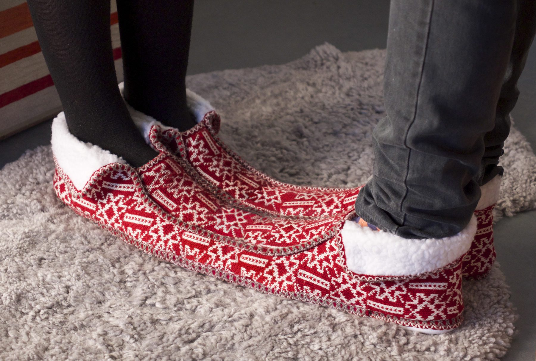 Two mismatched red knitted slippers